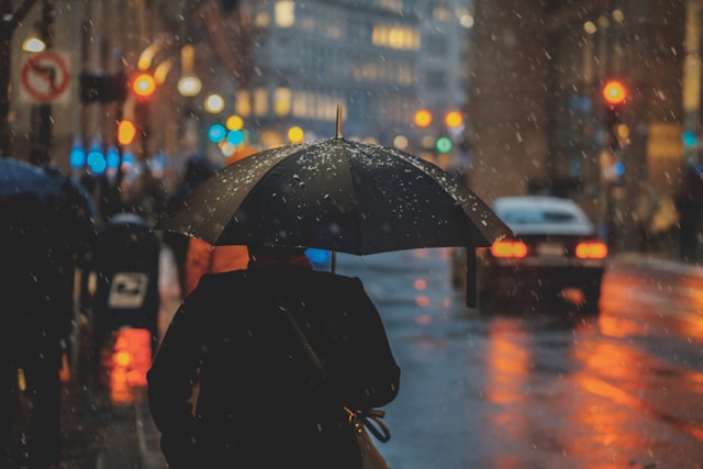 雨の中傘をさす男性